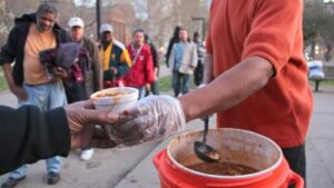 man serving food to homeless